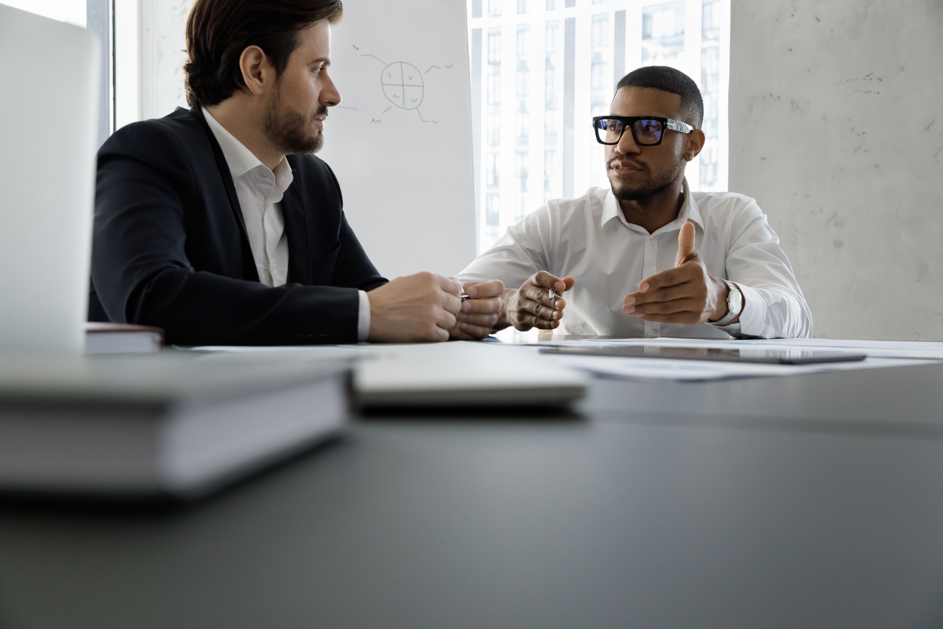 Diverse business partners discussing project at meeting table